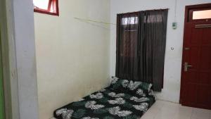 a room with a couch in a room with a door at SPOT ON 93712 Vanda Family in Blitar