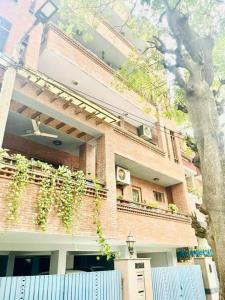 a brick building with a balcony with plants on it at Divine India Service Apartment 4Bhk,D-36, Saket in New Delhi