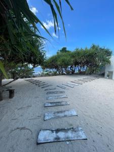 a stepping stone path on a beach with trees at Chalaroste Place by SMS Hospitality in Bolinao