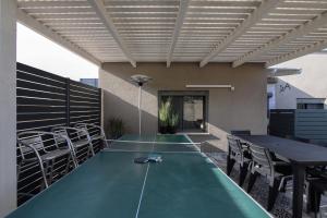 a ping pong table in the middle of a patio at 54You in Ahuzat Barak