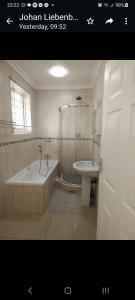 a bathroom with a tub and a toilet and a sink at Afsaal Sea view apartments in Amanzimtoti