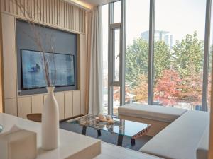 a living room with a couch and a large window at UH Suite The Seoul in Seoul +30 photos