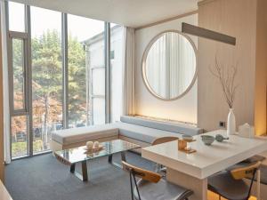 a living room with a table and a mirror at UH Suite The Seoul in Seoul