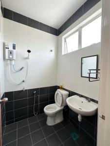 ein Bad mit einem WC und einem Waschbecken in der Unterkunft Fourteen Homestay in Port Dickson