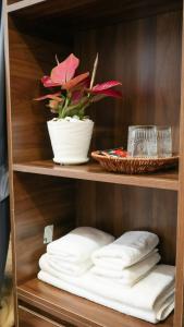 a wooden shelf with towels and a plant on it at Cá Homestay-Cao Bằng in Cao Bằng