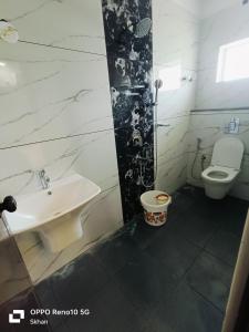 a bathroom with a toilet and a sink at Golden Residency in Kushālnagar