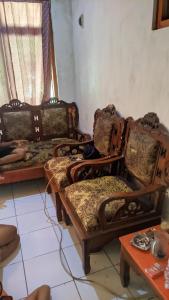 uma sala de estar com duas cadeiras e uma mesa em Kostel Al-Barokah 