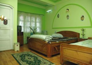 een groene slaapkamer met een bed en een raam bij Mirik Sarangi Homestay in Mirik