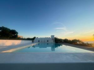 a view of a swimming pool at sunset at Chalaroste Place by SMS Hospitality in Bolinao