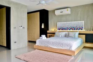 ein Schlafzimmer mit einem großen Bett und einem rosa Teppich in der Unterkunft Villa Papaya @ Kamala Beach in Kamala Beach + 18 Fotos