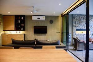 ein Wohnzimmer mit Sofa und Fernseher in der Unterkunft Villa Papaya @ Kamala Beach in Kamala Beach