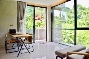 Zimmer mit einem Schreibtisch und einem Tisch mit einem Laptop in der Unterkunft Villa Papaya @ Kamala Beach in Kamala Beach