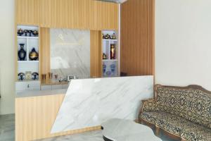 Habitación con sofá y estanterías de jarrones en Urbanview Hotel Tritia Lampung en Kedaton