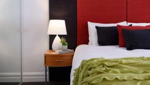 a bedroom with a bed and a table with a lamp at Lakeside Suite 2 - Lake View & Spa Bath in Daylesford