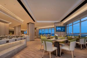 a rendering of a restaurant with tables and chairs at Howard Johnson Airport Serviced Residence Changsha in Changsha