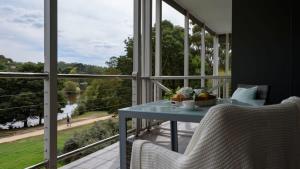 a balcony with a blue table and a large window at Lakeside Suite 1 - Lake View & Spa Bath in Daylesford