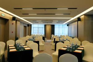 una sala de conferencias con mesas y sillas en un edificio en Howard Johnson Airport Serviced Residence Changsha, en Changsha