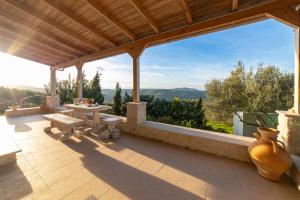 einen Pavillon mit einem Tisch und Vasen auf einer Terrasse in der Unterkunft Villa Vitsilias under the cretan sky in Aïtánia