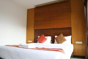 a bedroom with a bed with white sheets and pillows at Diamond Crown in Patong Beach