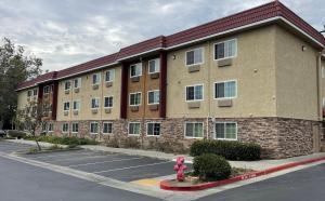 un edificio con una boca de incendios roja en un aparcamiento en Red Roof Inn Hayward, en Hayward