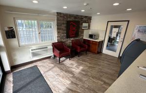 a waiting room with two red chairs and a counter at Red Roof Inn Hayward in Hayward