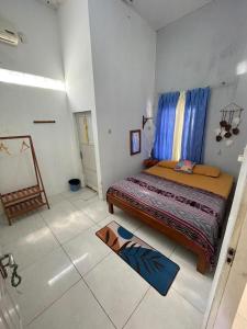 1 dormitorio con cama y alfombra en el suelo en Loyal friend hostel karimunjawa en Karimunjawa