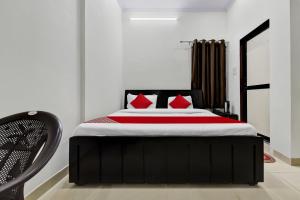 1 dormitorio con 1 cama grande con almohadas rojas en OYO Pari Residency en Jaipur