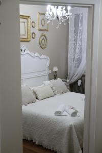 a bedroom with a white bed and a chandelier at Castelvecchio Loft in Verona