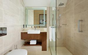 a bathroom with a sink and a shower at Courtyard by Marriott Baku in Baku