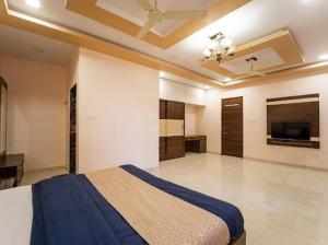 a bedroom with a bed and a tv in it at Zenith Villa in Panchgani