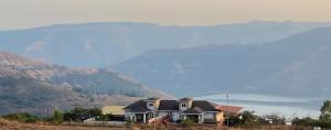 a house on a hill with mountains in the background at Zenith Villa in Panchgani