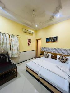 a bedroom with a large white bed and yellow walls at Hotel Payal Jaisalmer in Jaisalmer