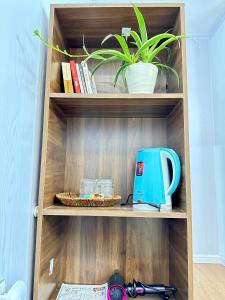 a wooden shelf with a tea kettle and a plant at Cá Homestay-Cao Bằng in Cao Bằng