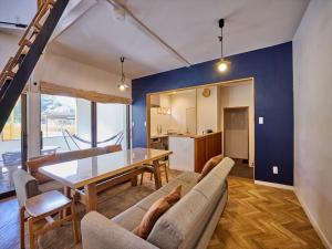 a living room with a couch and a table at 河口湖でアウトドアを楽しむコテージCottage Harvest tree in Fujikawaguchiko