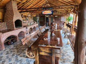 a restaurant with wooden benches and a brick fireplace at Refugiul Rustic in Arad