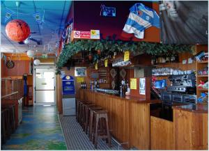 a restaurant with a bar with stools and a counter at Hostel San Marino in San Marino