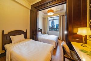 a hotel room with two beds and a desk and a window at Yeoksam Artnouveau City Hotel and Residence in Seoul