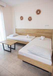 two beds and a table in a room at House Kohili in Nea Vrasna