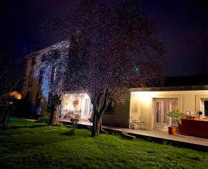 una casa con un árbol en el patio por la noche en Chez Guilem, en Saint-Maixent-lʼÉcole