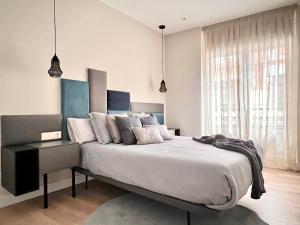 - une chambre avec un grand lit et une grande fenêtre dans l'établissement Varillas Luxury Home I y II, à León