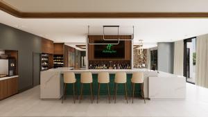 uma cozinha com um bar com bancos verdes em Holiday Inn Nashville Airport, an IHG Hotel em Nashville