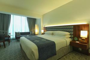 una camera d'albergo con un grande letto e una sedia di Peshawar Serena Hotel a Peshawar