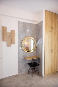 a mirror on a wall in a room with a chair at House Kohili in Nea Vrasna