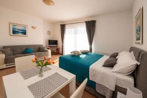 a room with a bed and a couch and a table at Apartmani Trogir in Trogir