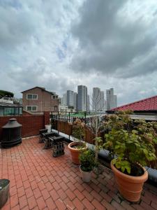 un patio avec des plantes et des bancs sur un toit dans l'établissement Space in Blackstone, à Séoul