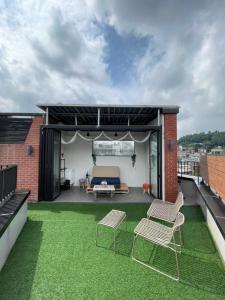 a patio with chairs and a couch on a roof at Space in Blackstone in Seoul