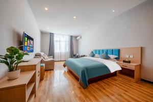 昆明市にあるMando Hotel - Kunming Changshui International Airportのベッドとソファ付きのホテルルーム