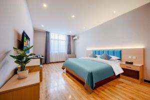 a bedroom with a large bed and a television at Mando Hotel - Kunming Changshui International Airport in Kunming