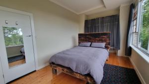 a bedroom with a bed and a window at Architects Summer House, Mt Lofty Gardens in Crafers