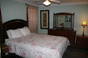 een slaapkamer met een bed, een dressoir en een spiegel bij Royal North Beach in Clearwater Beach